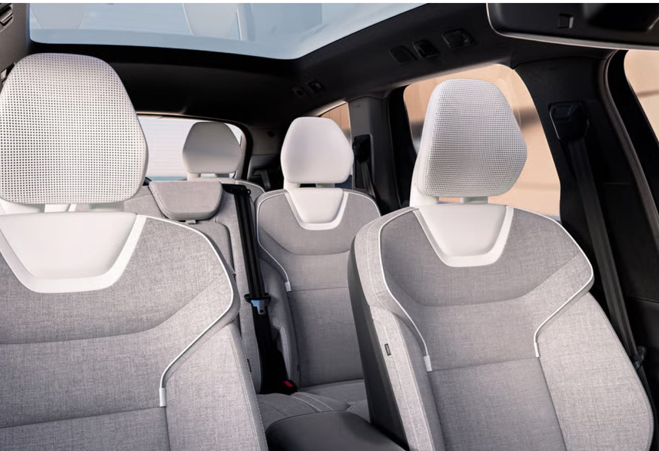 Volvo EX90 interior with light gray fabric seats and sleek white trim.
