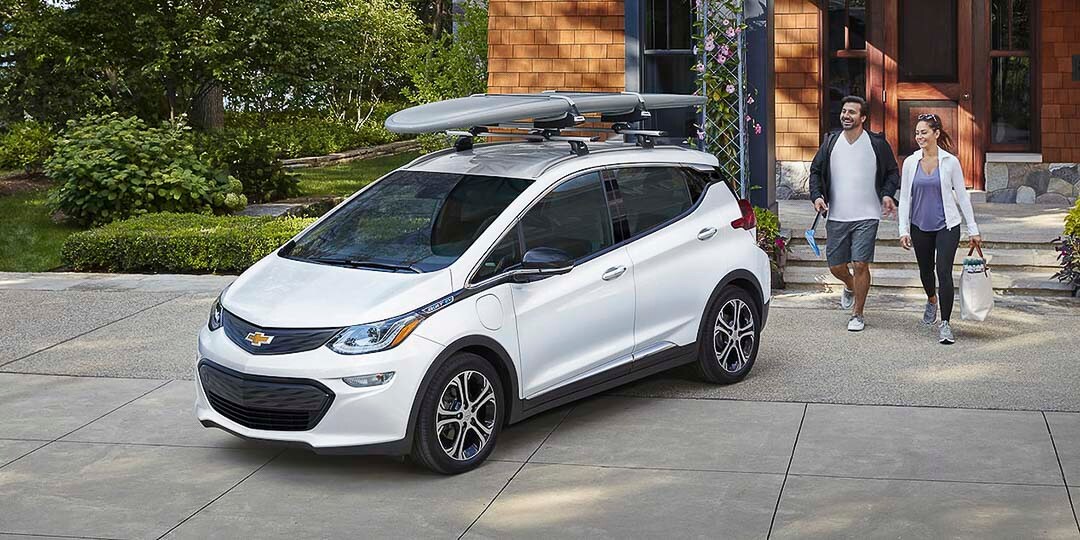 vue trois quart avant du Chevrolet Bolt EV 2021 stationné en avant d'une maison