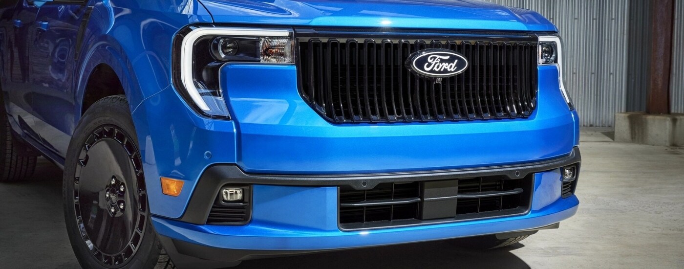 Close-up on the grille of a blue 2026 Ford Maverick.