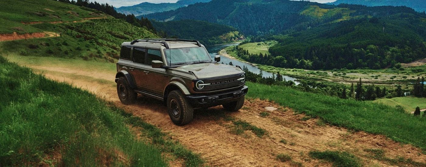 2027%20Ford%20Bronco%20Filson%20-%20Valley.jpg Grey 2027 Ford Bronco Filson driving on a trail