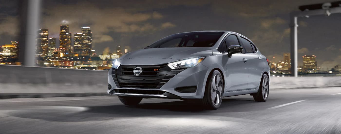 wlp%20-%202025%20Nissan%20Versa%20for%20Sale%20in%20Lima%20-%20Silver.jpg A silver 2025 Nissan Versa SR driving in a city at night