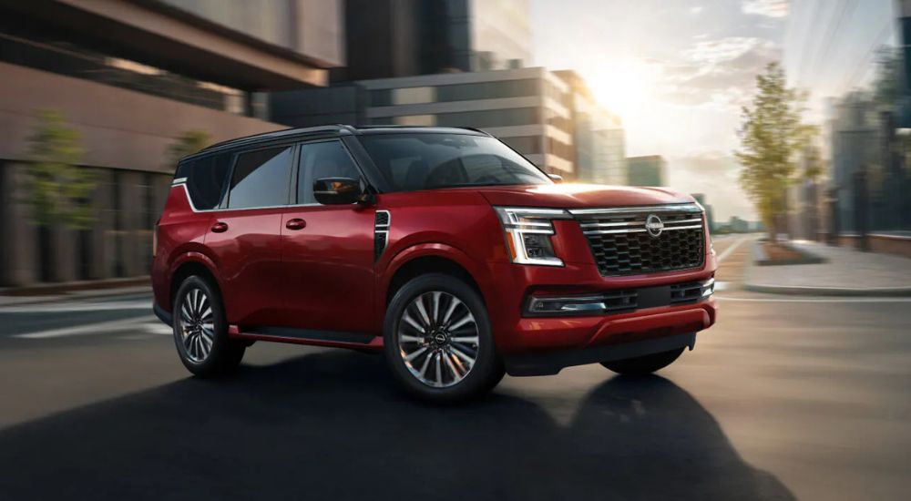 A red 2025 Nissan Armada PRO-4X driving through a city.