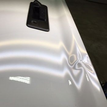 Large dent on liftgate before repair at Reliable Collision Center in Springfield Missiouri