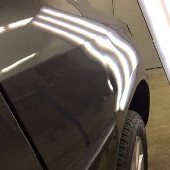 Small dent near wheel arch before repair at Reliable Collision Center in Springfield Missiouri