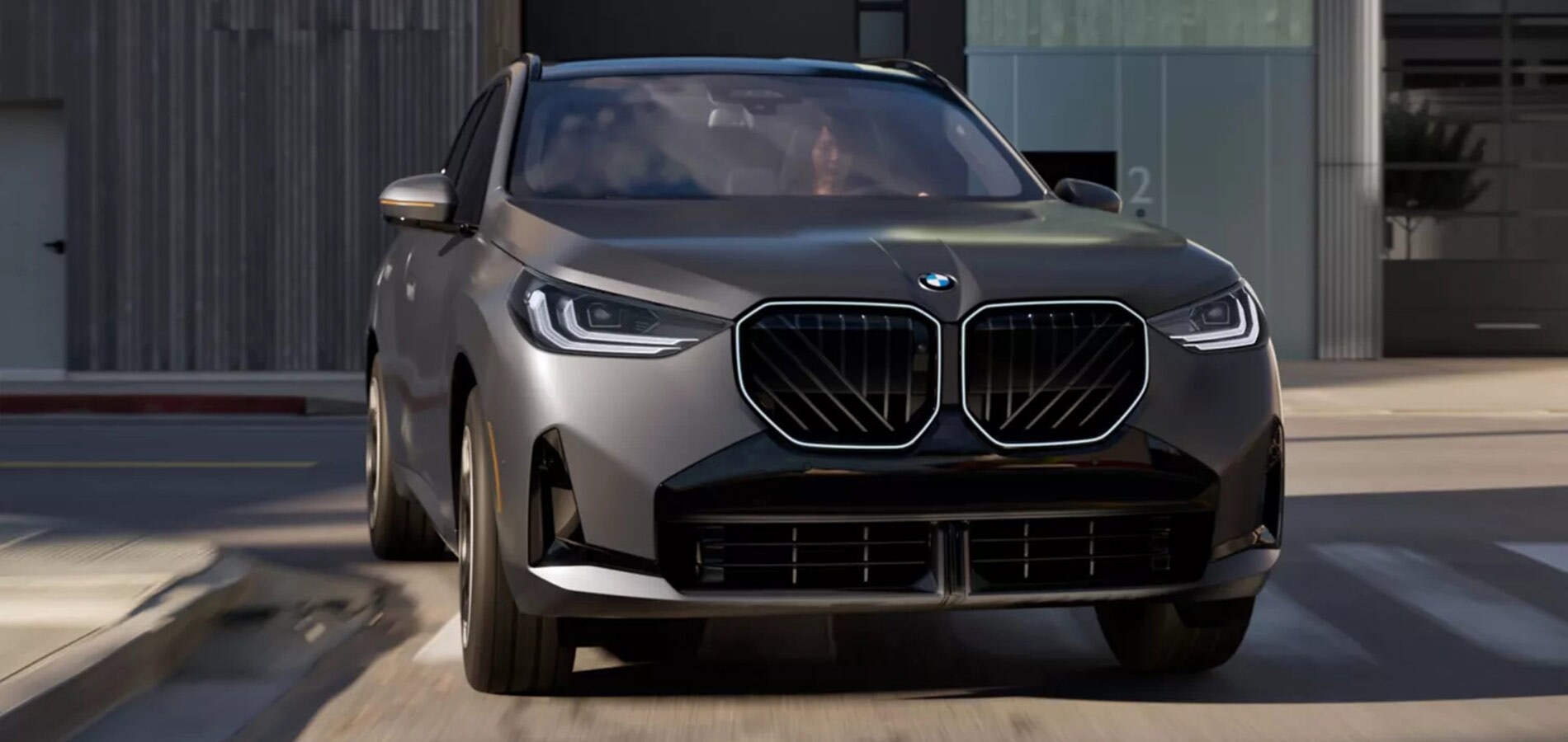 Pre-Owned Luxury BMWs For Sale Near Me A gray BMW X3 rounding a corner on the road.