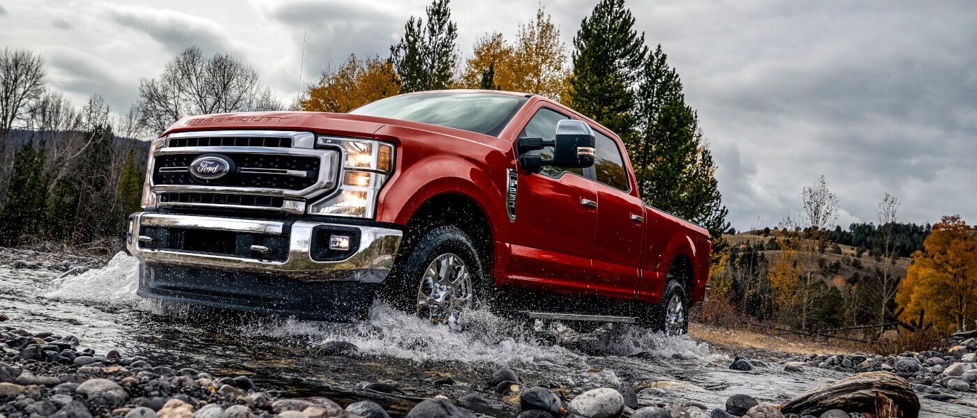 2022 Ford Super Duty driving through a rocky riverbed