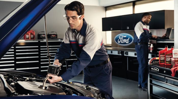 A Ford service worker changing oil