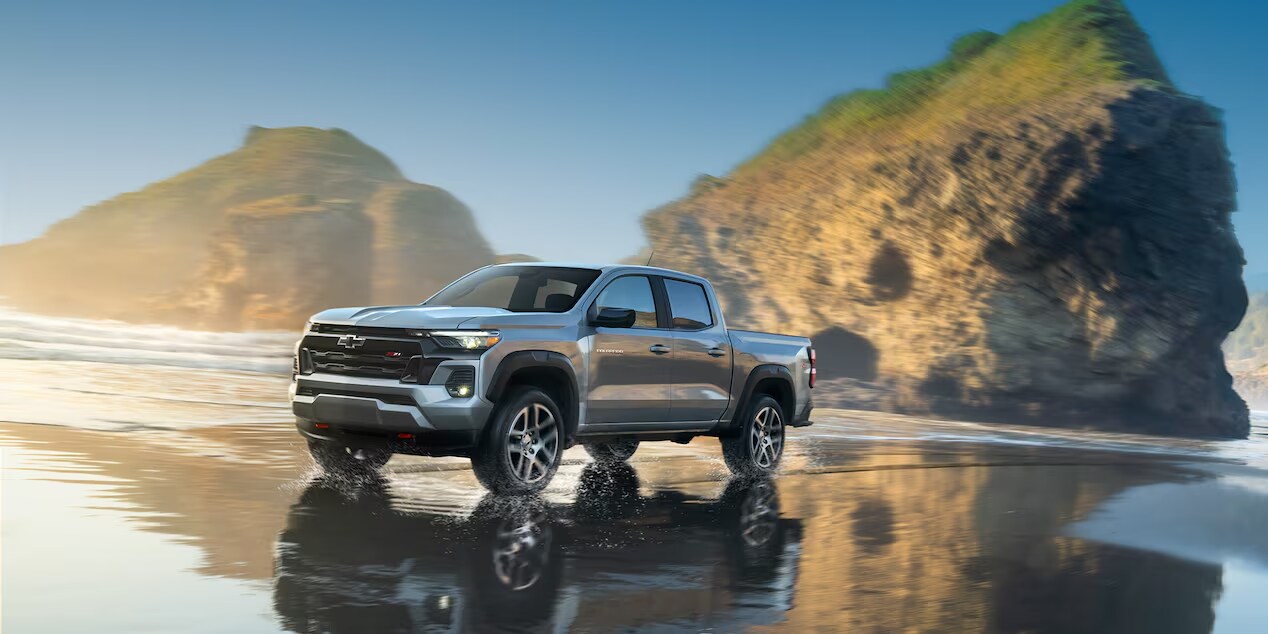 A Chevrolet Colorado parked on the beach, showcasing its ruggedness and versatility amidst the scenic coastal backdrop.