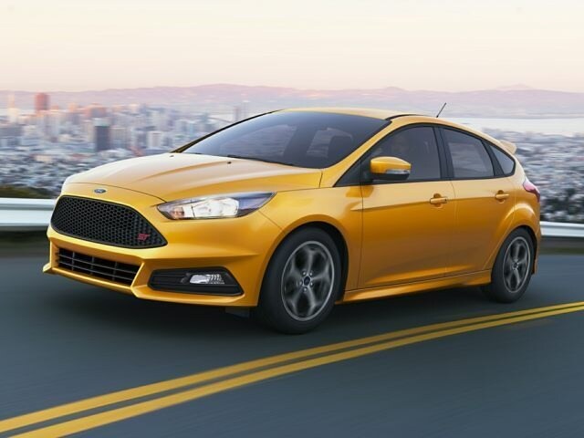 2017 Ford Focus ST hatchback yellow driving against cityscape.jpg