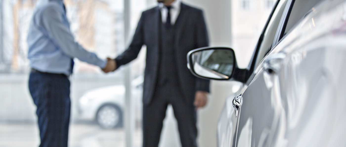 Toyota Finance Center Two people shaking hands in front of a vehicle