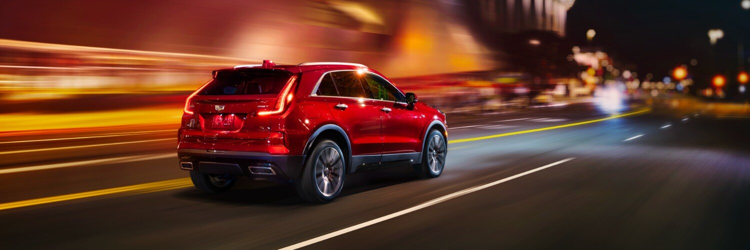 CADILLAC XT4 SUV driving down a highway at night new CADILLAC XT6