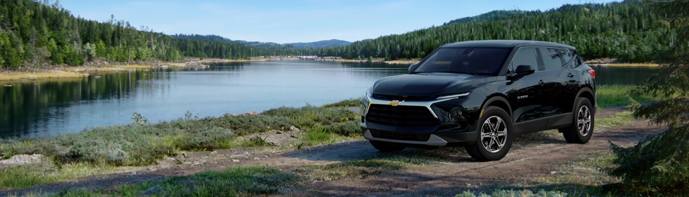 2025 Chevy Blazer Black 2025 Chevrolet Blazer driving on grassy road next to a large lake