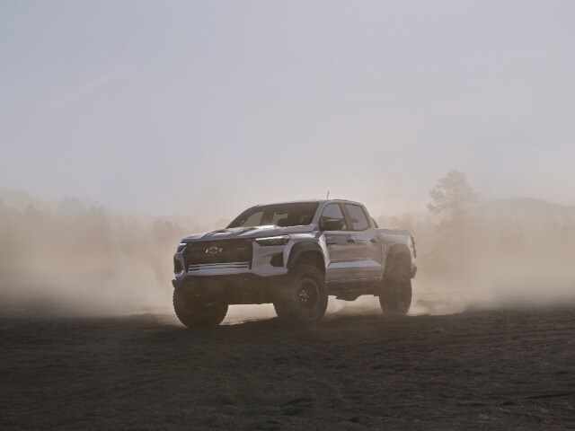 Chevy Colorado Silver Chevrolet Colorado driving on dusty off-road terrain