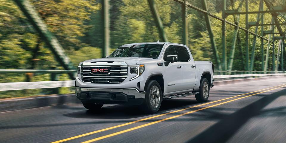 A powerful 2026 GMC Sierra 1500 driving on an open road.