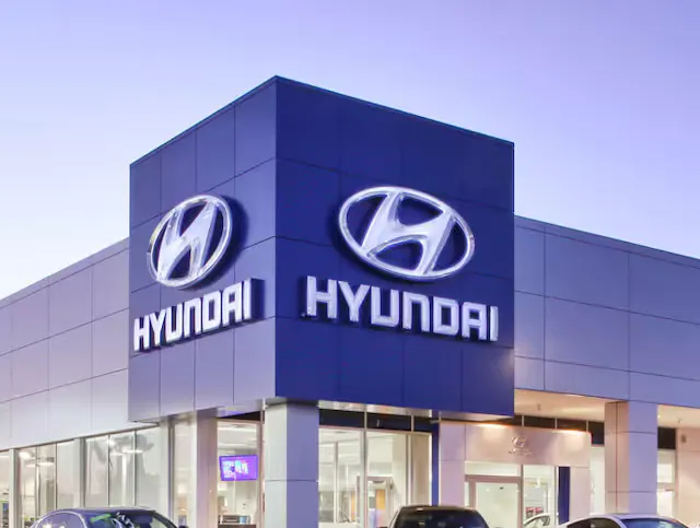 A friendly dealership employee smiling and ready to assist customers.