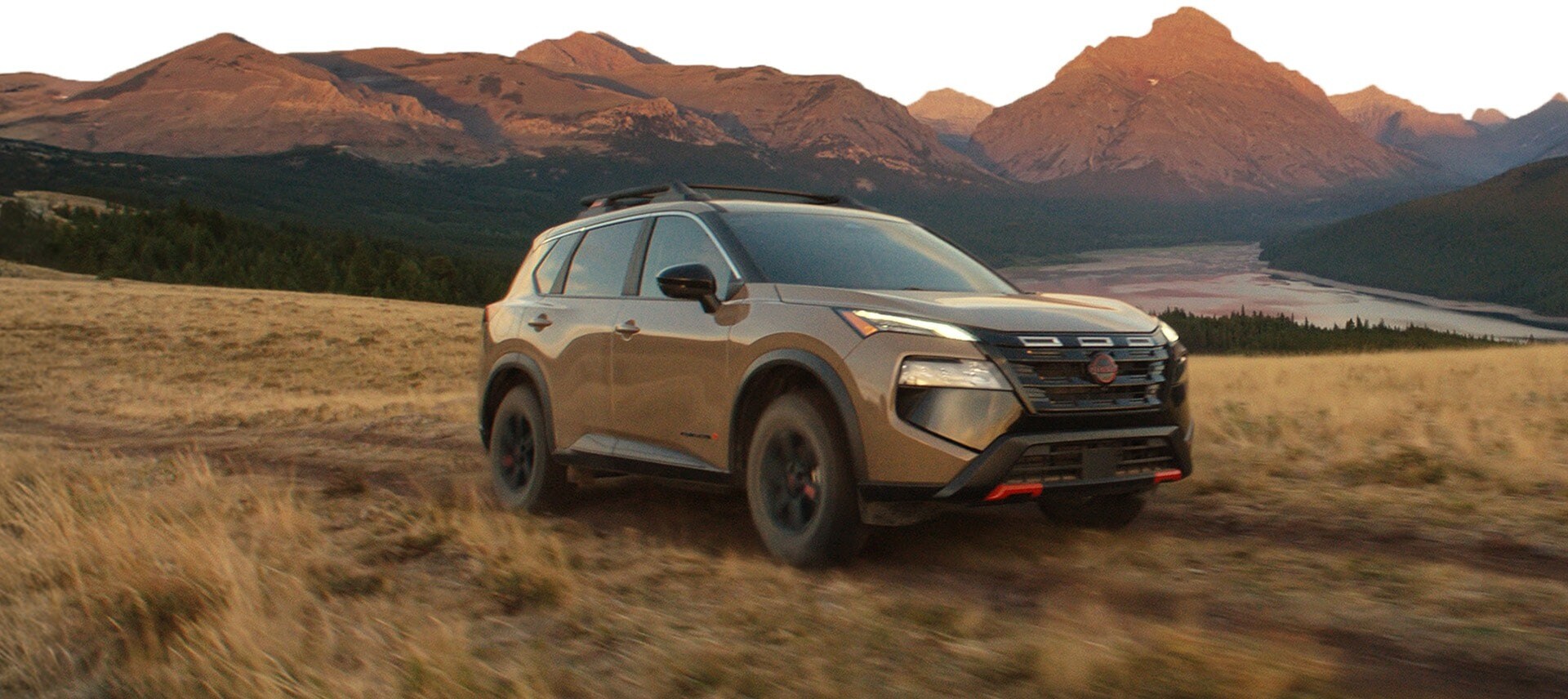 2026 Nissan Rogue Rock Creek exterior, highlighting all-terrain tires and roof rack.