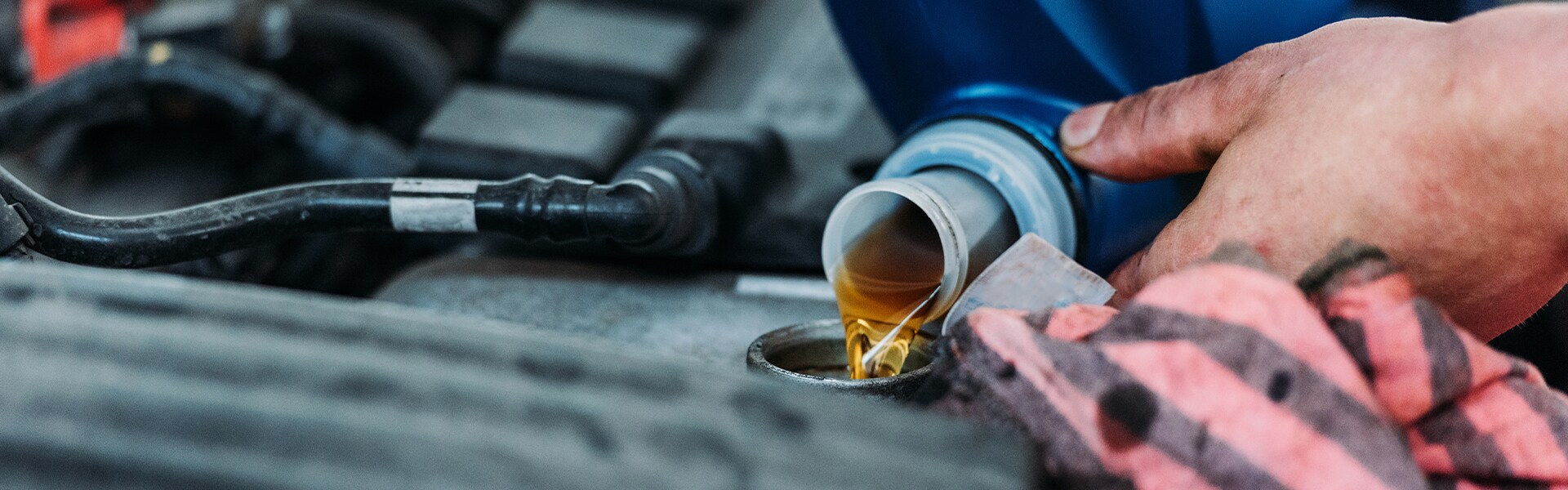 Benefits of Changing Your vehicle’s Oil at Sale Auto Mall in Kinston | Service Advisor Pouring New Oil Into Car Engine