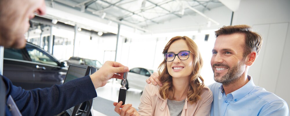 couple getting keys to new car