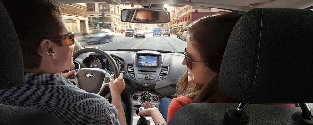 couple driving ford in city