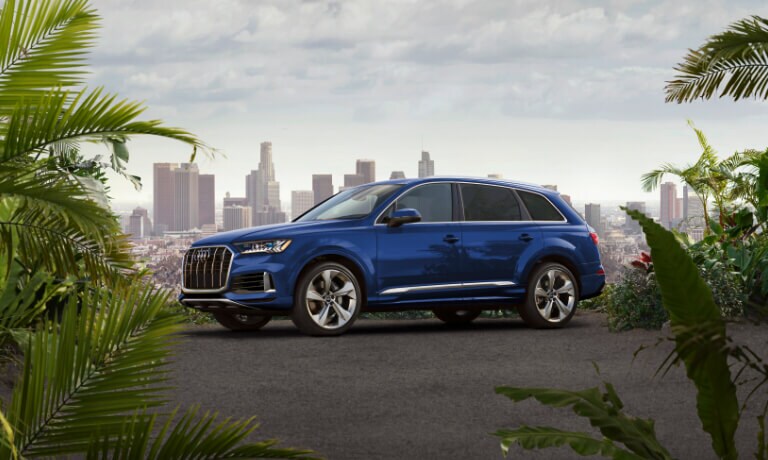 Blue 2020 Audi Q7 parked in front of a city skyline
