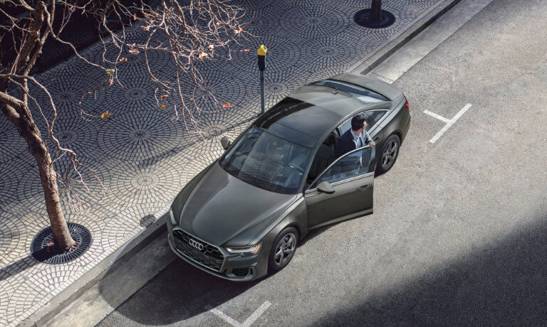 2025 Audi A6 Sedan exterior parked on street with driver exiting car