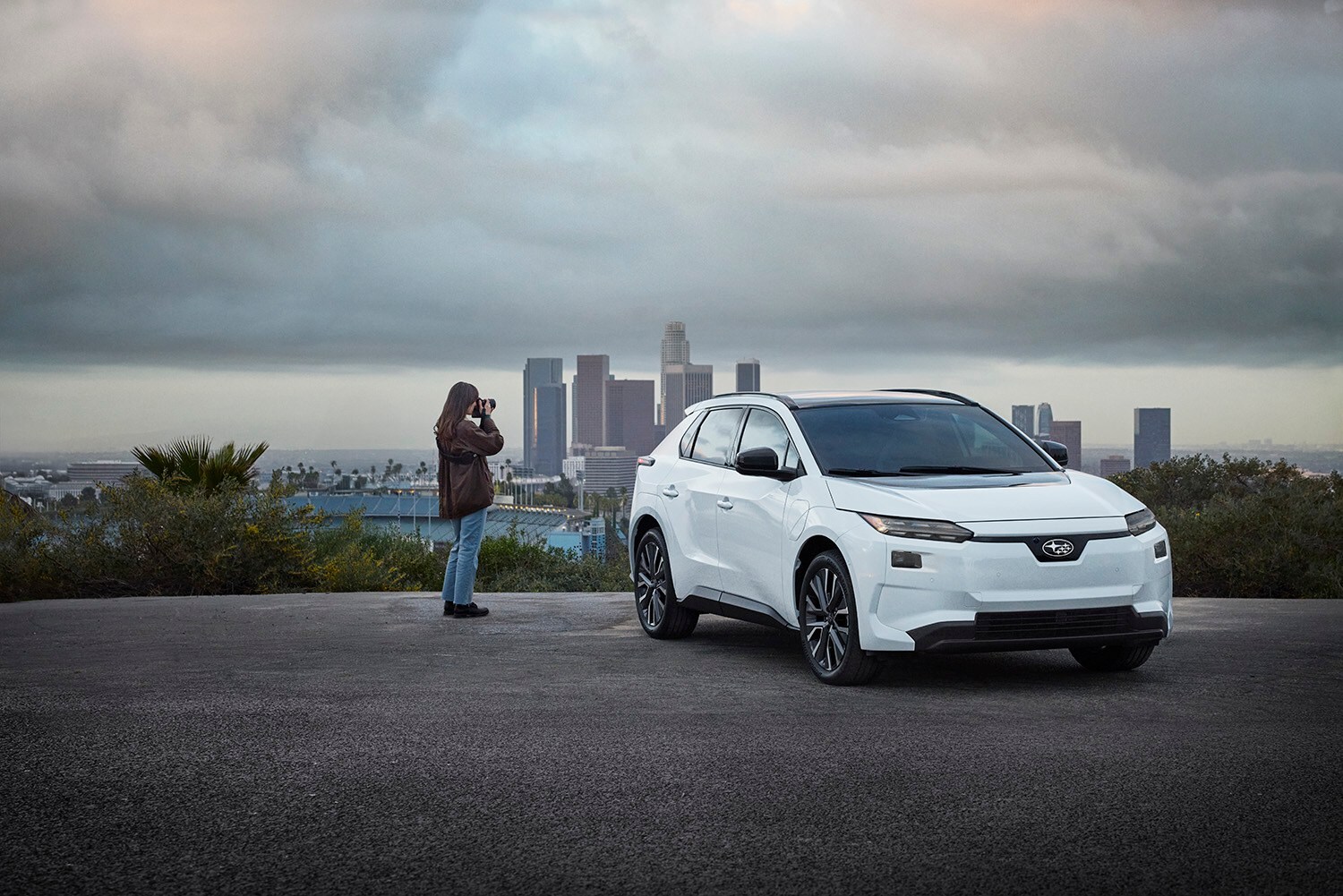 2026 Subaru Solterra Limited in Crystal White Pearl at an urban overlook with palms
