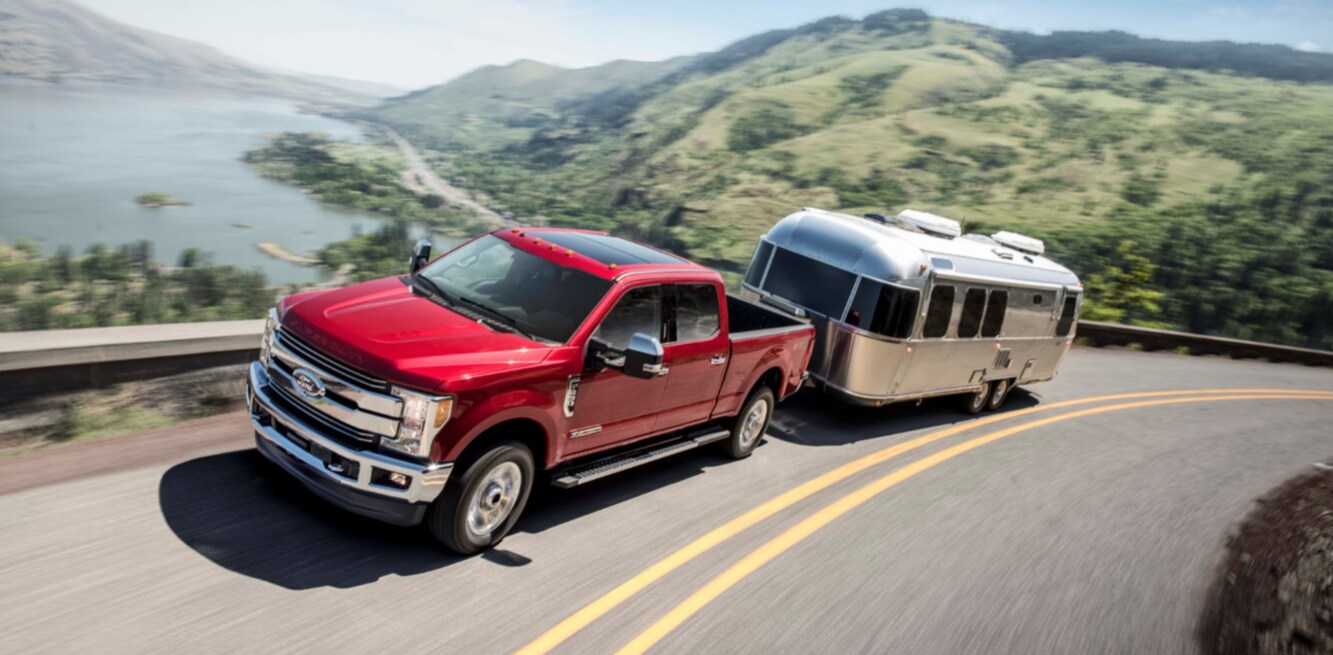 truck_mountains_3.png Red F-250 towing a trailer through the mountains
