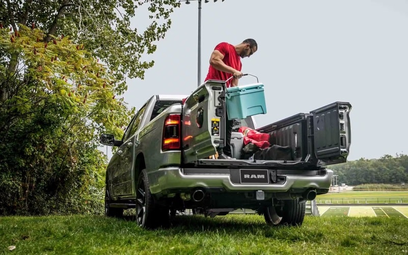 Back view of Ram truck with pickup backdoors open and man standing inside