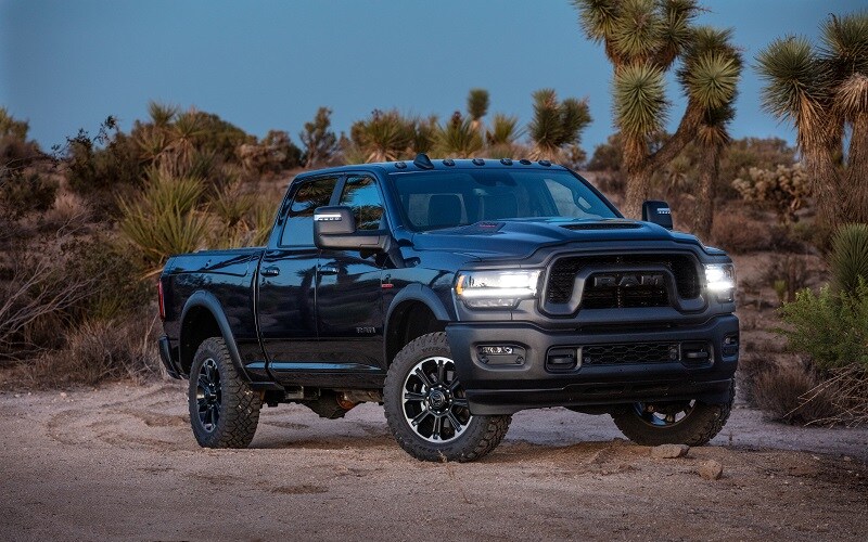 Ram 2500 truck parked in the sand with the headlights on