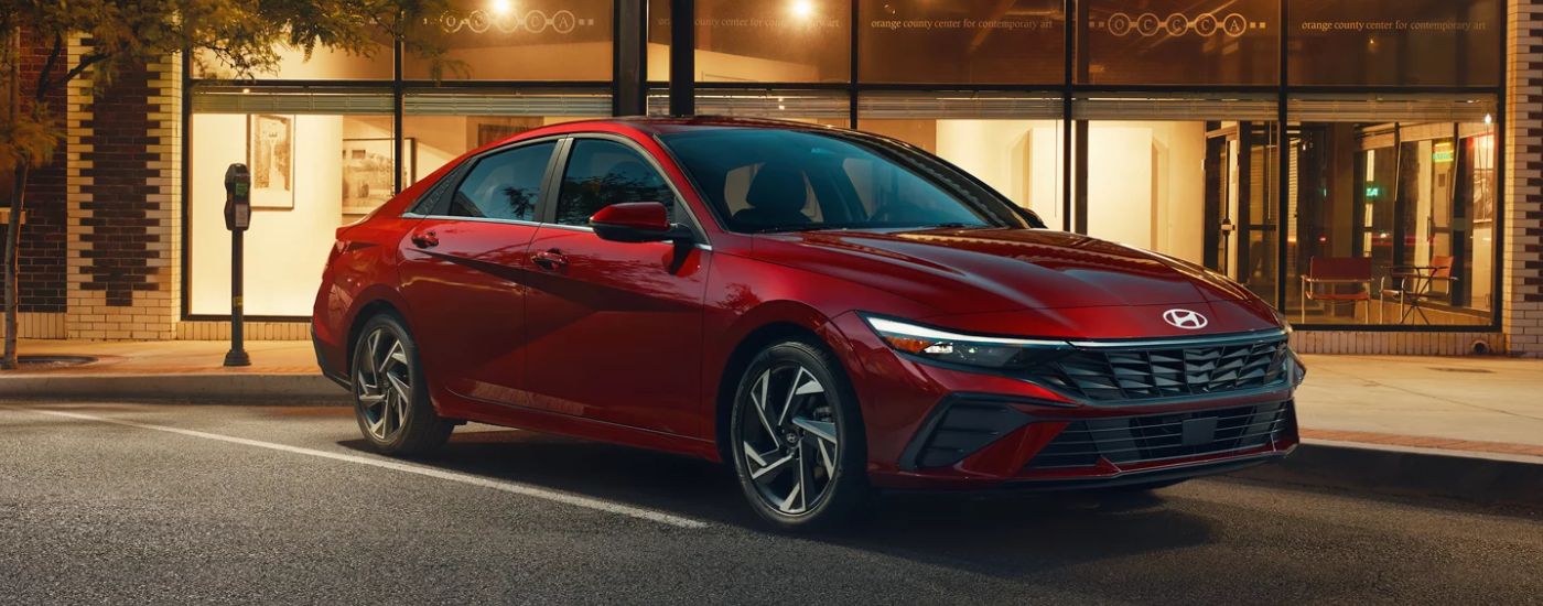 A red 2026 Hyundai Elantra parked outside an arts center.