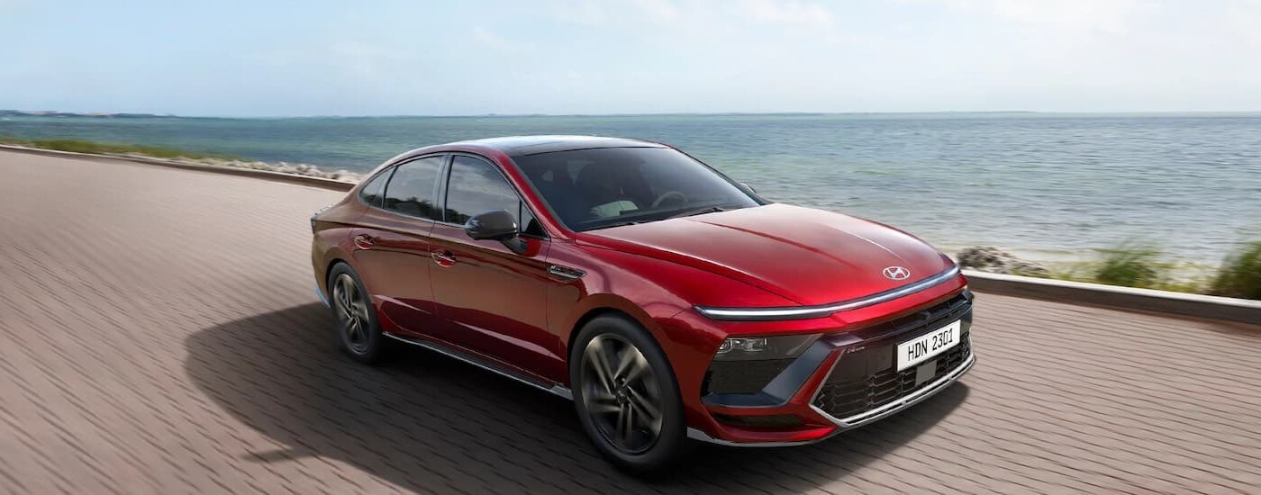 Red 2026 Hyundai Sonata driving down a road
