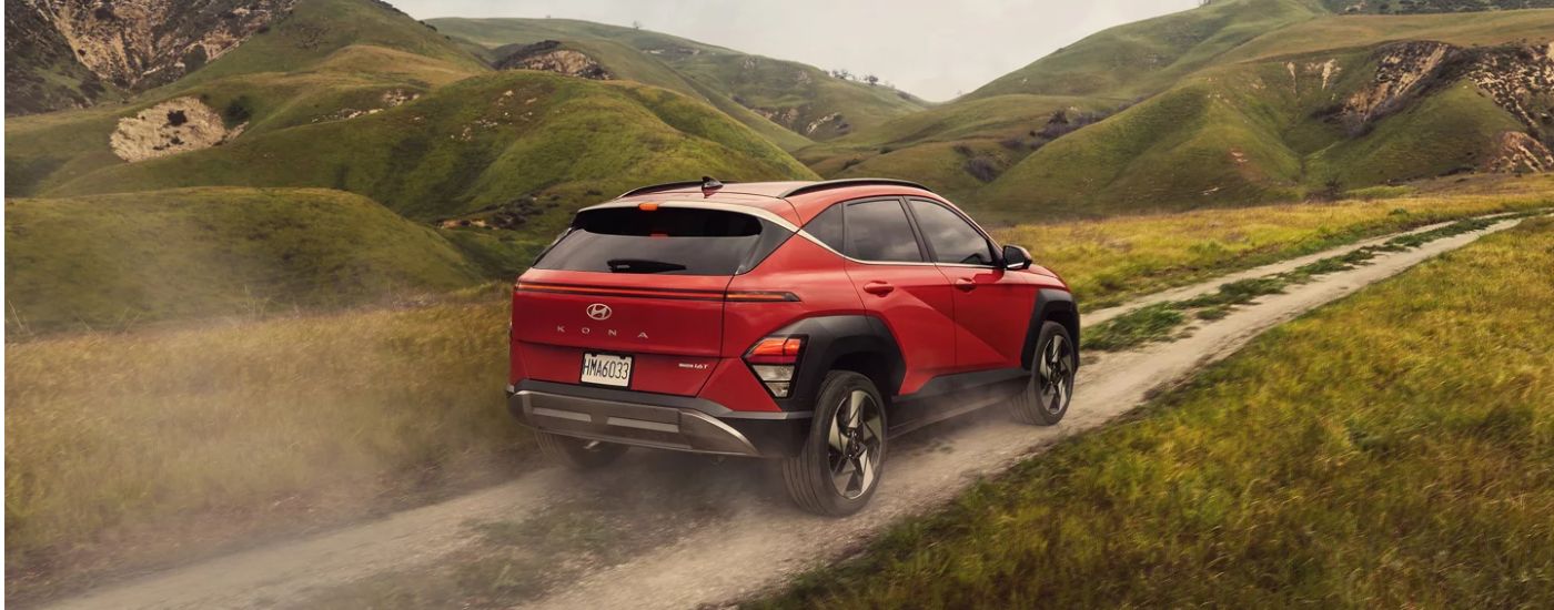 A red 2026 Hyundai Kona Limited driving a mountainous trail.