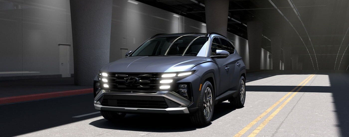 Grey 2026 Hyundai Tucson driving across a bridge.