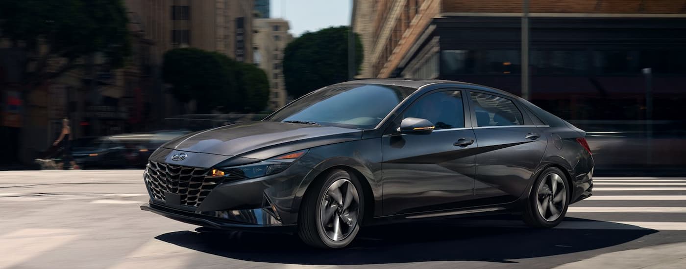 A gray 2022 Hyundai Elantra turning a city corner.