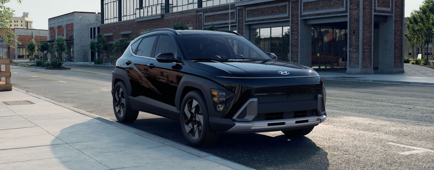 A black 2026 Hyundai Kona parked next to a sidewalk in a city.
