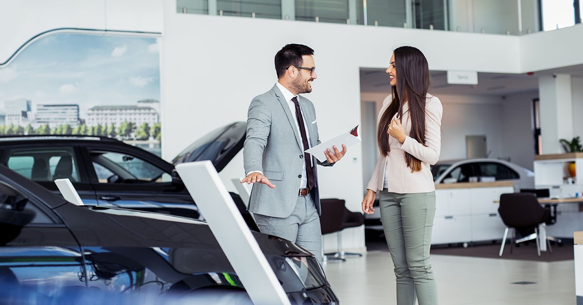 A Shea Chevrolet Sales Rep talking with a woman in a Chevy showroom.