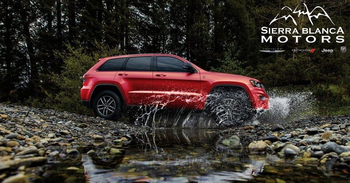 Red 2021 Jeep Grand Cherokee Driving Through Creek.jpg