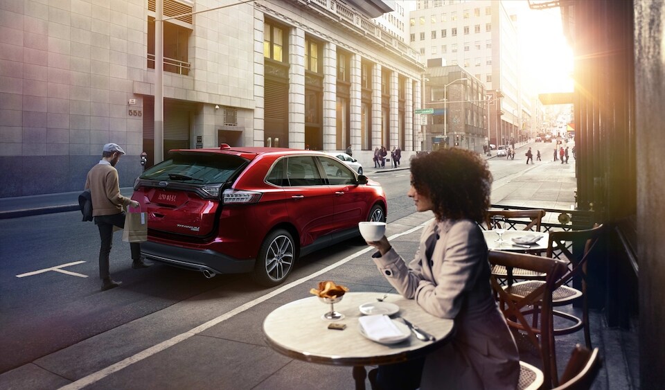 Ford-Lifestyle-Woman in cafe watching man load a Ford SUV.jpeg