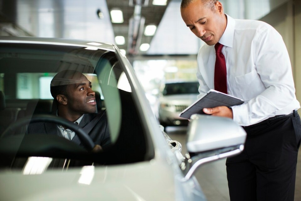 African-american man in driver seat of Lincoln talking to sales person.jpeg