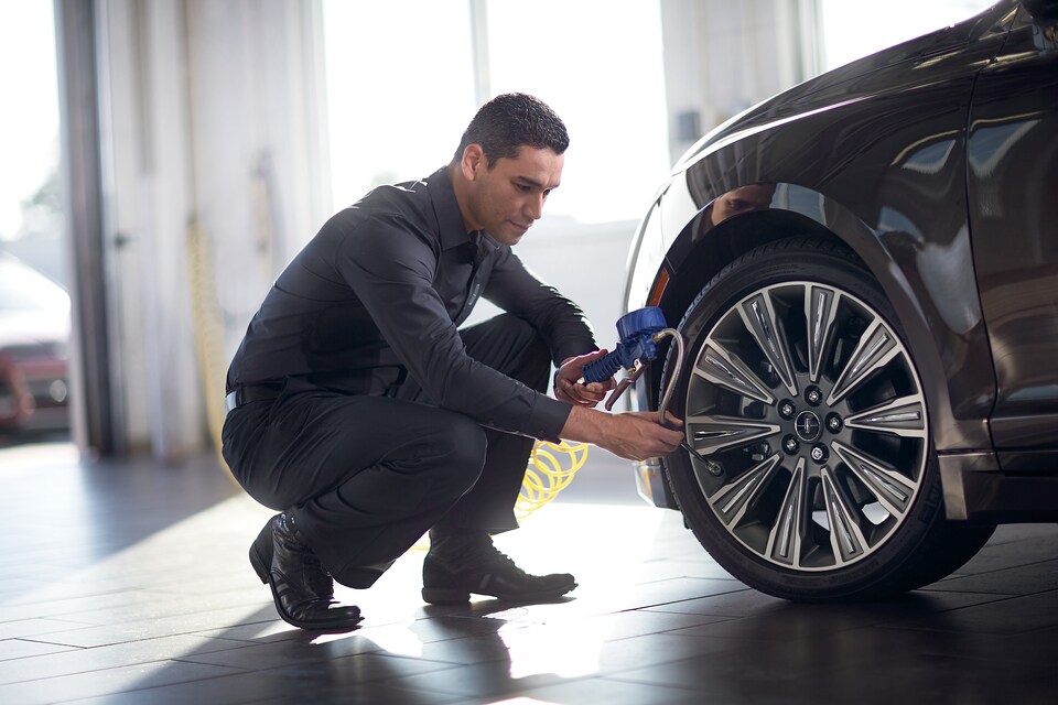 Lincoln service technician checking tire pressure.jpeg