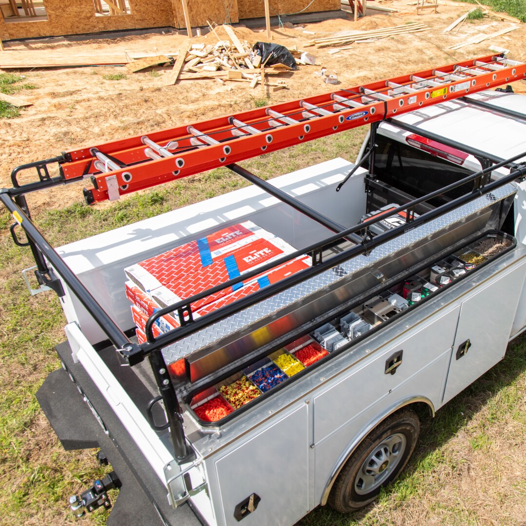 Service body truck fitted with a ladder rack