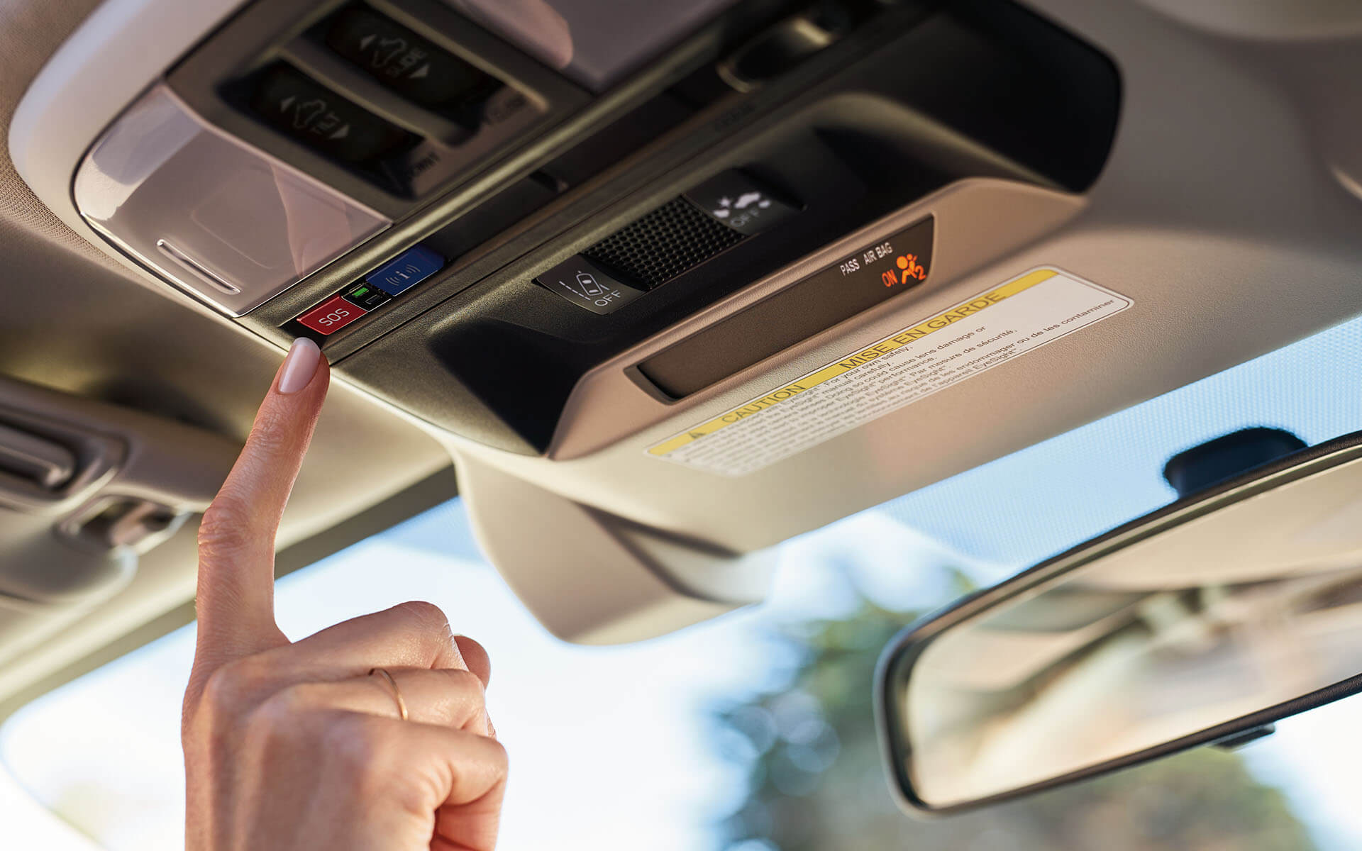 A finger pressing the Crosstrek's SOS Emergency Assistance button