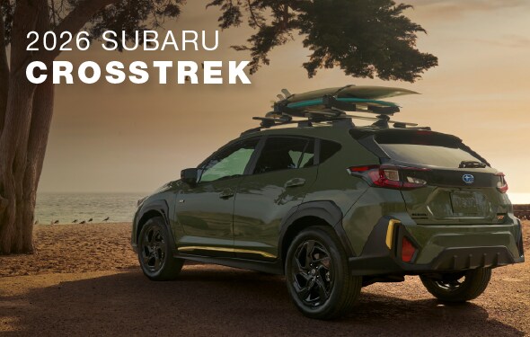 2026 Subaru Crosstrek lifestyle image - AWD compact SUV parked on Fort Lauderdale beach with roof rack carrying surfboards, perfect for South Florida outdoor activities and commuting