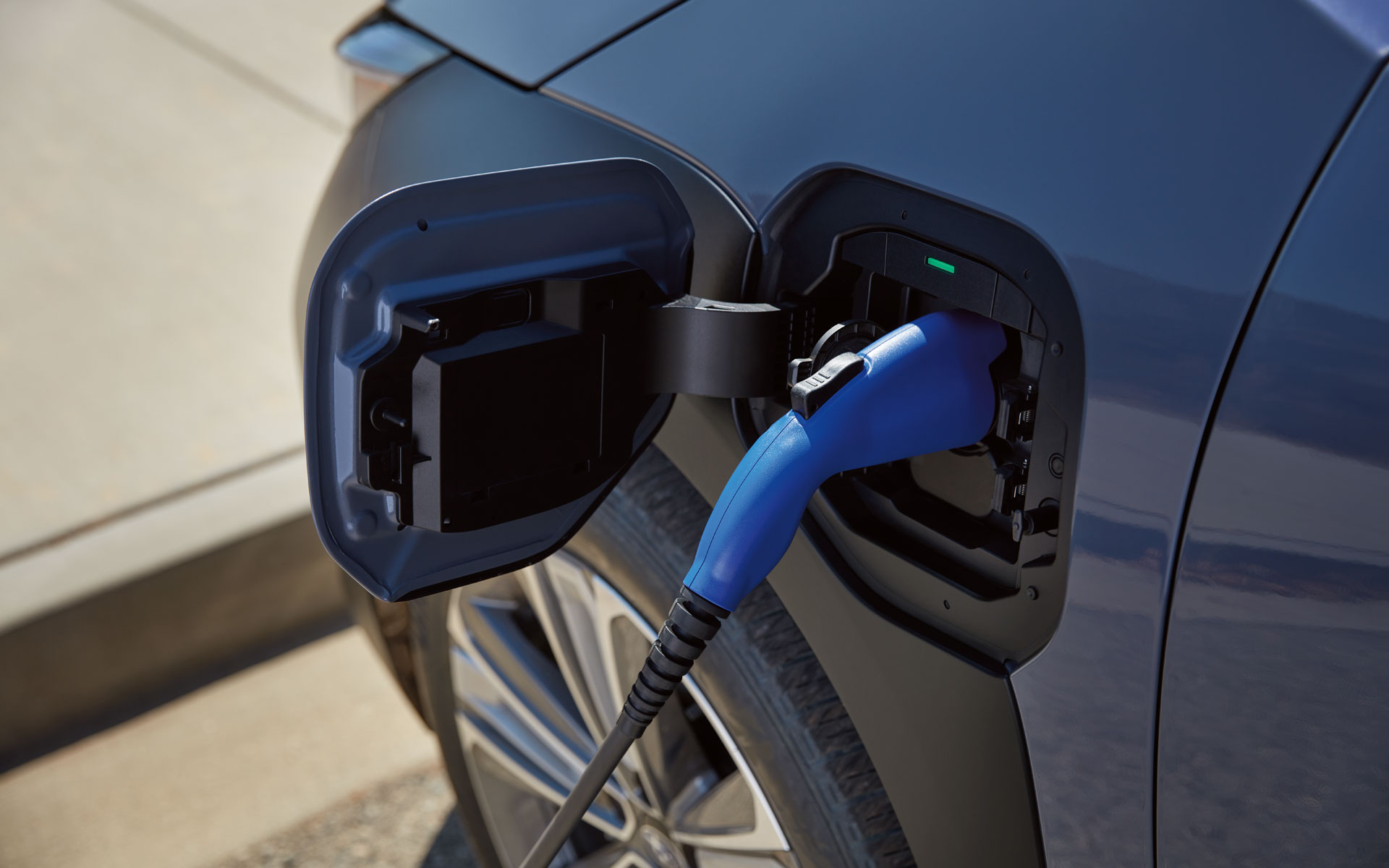 A close-up of a charger plugged into the charging port of the 2024 Subaru Solterra all electric SUV.