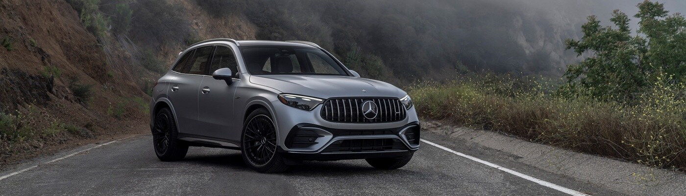 Mercedes-Benz AMG® GLC Silver Mercedes-Benz AMG GLC parked on a foggy road