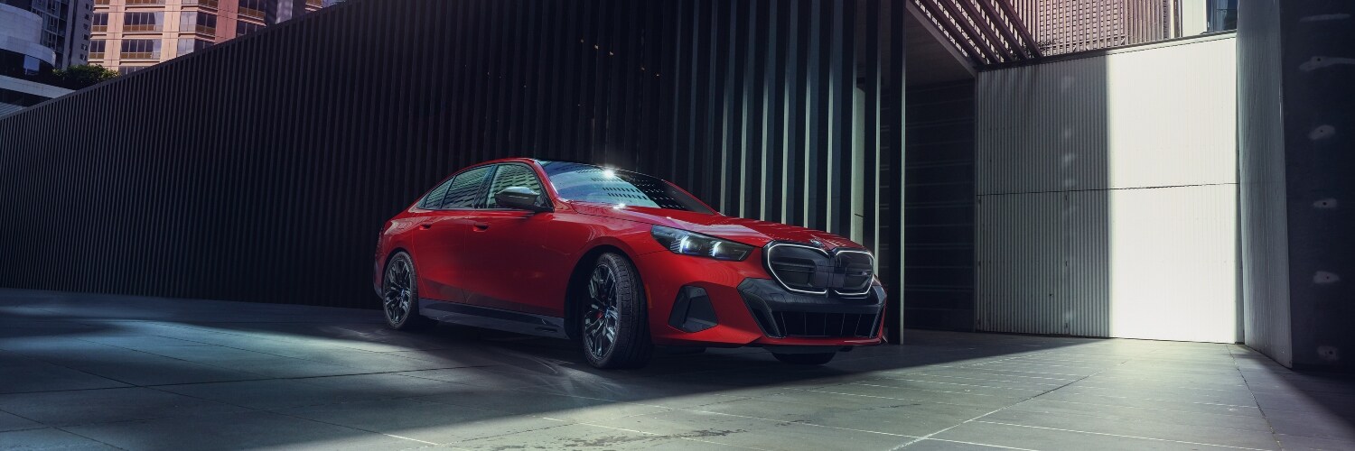 2025 BMW i5 red 2024 BMW i5 parked in city setting
