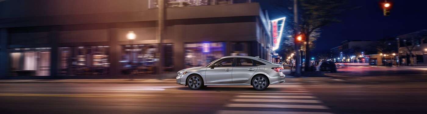 Honda Civic Hybrid White Civic Sport Touring Hybrid driving in a city at night