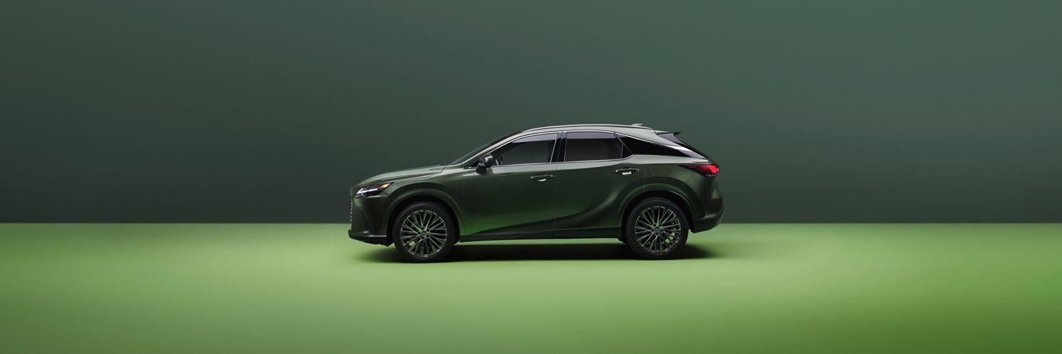 Lexus RX hybrid side view of a dark green Leuxs RX 450h+ Hybrid SUV in a large room with green floor and walls