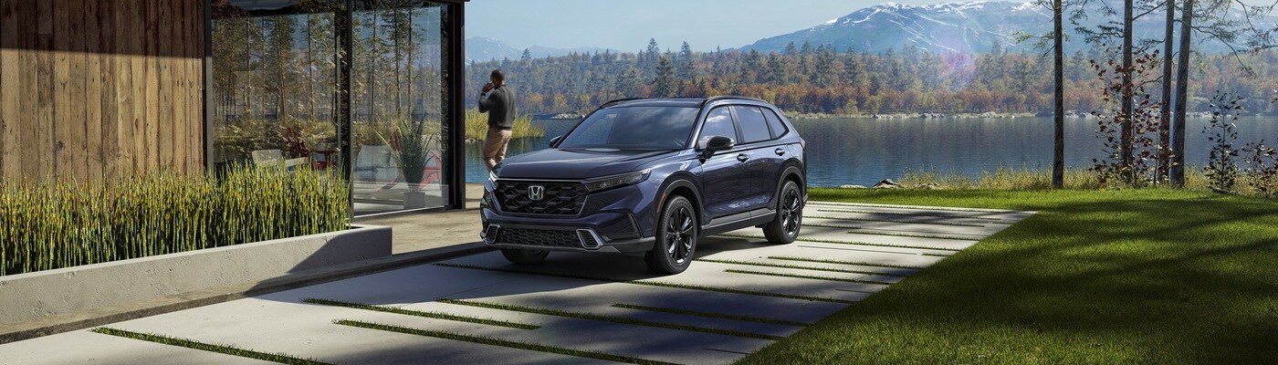 Honda CR-V Hybrid Blue CR-V Hybrid parked beside a modern lakehouse