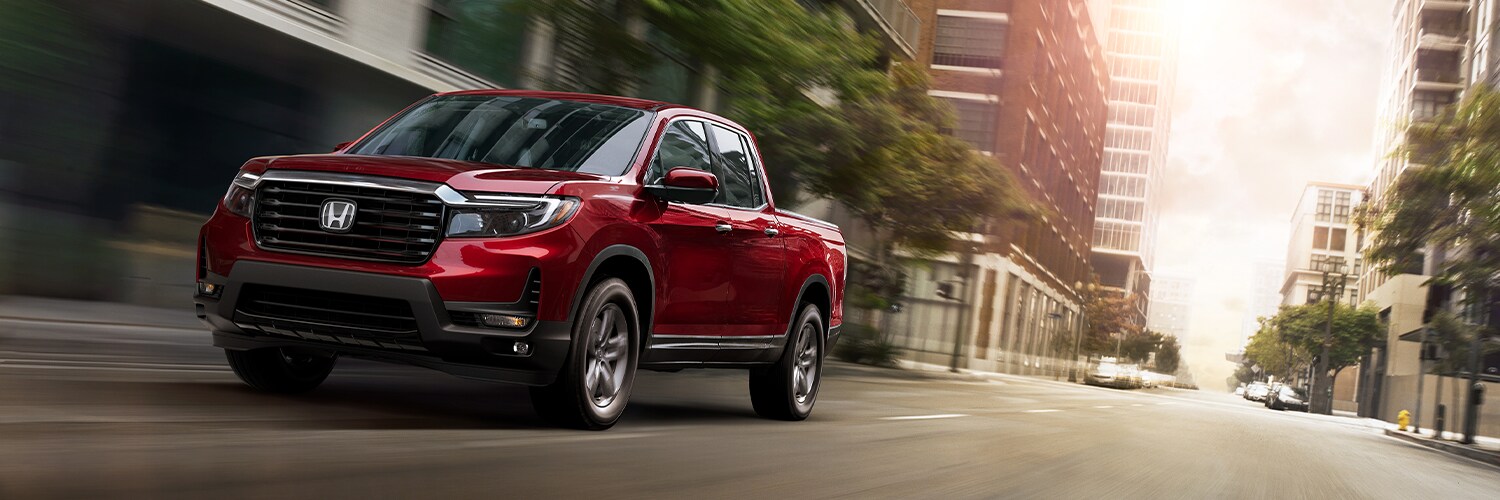 Honda Ridgeline Red Ridgeline driving through a city